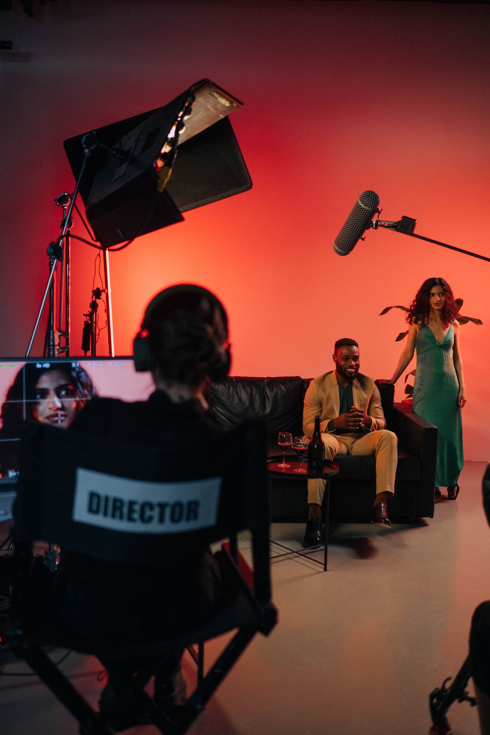 Behind the scenes of a film set with director and actors during a vibrant indoor shoot.